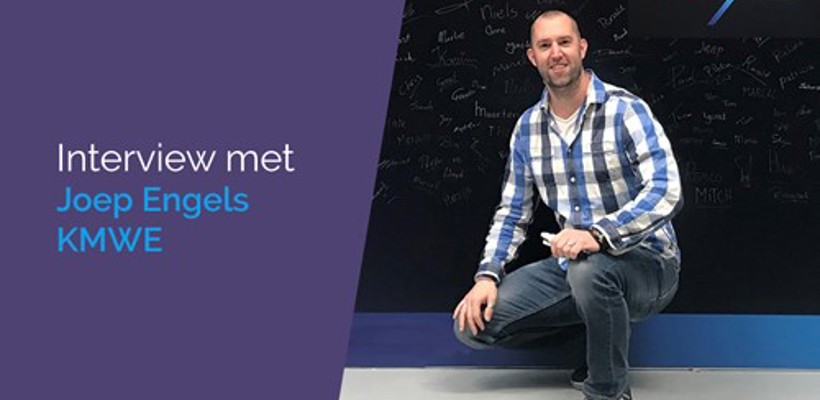 Een man die hurkt voor een schoolbord