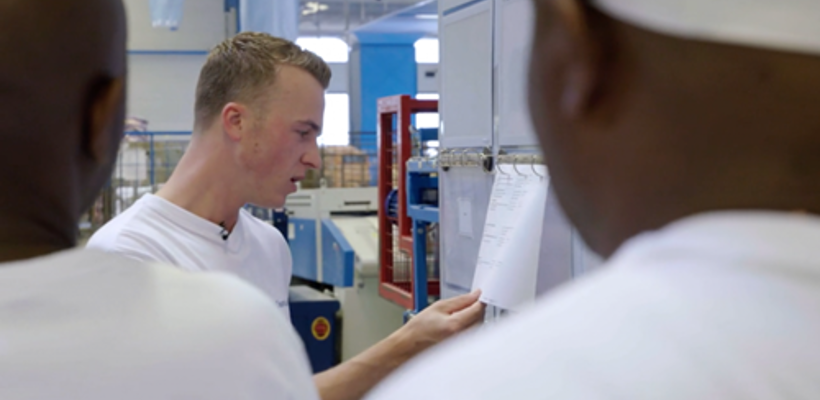 Een man in een wit shirt die naar een stuk papier kijkt